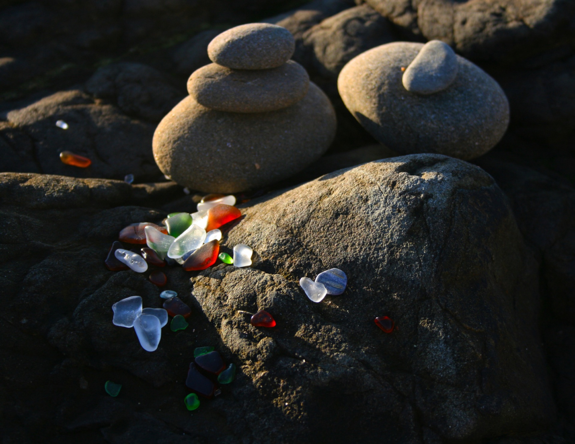 Sea glass and wave-worn stones on the shore at dusk